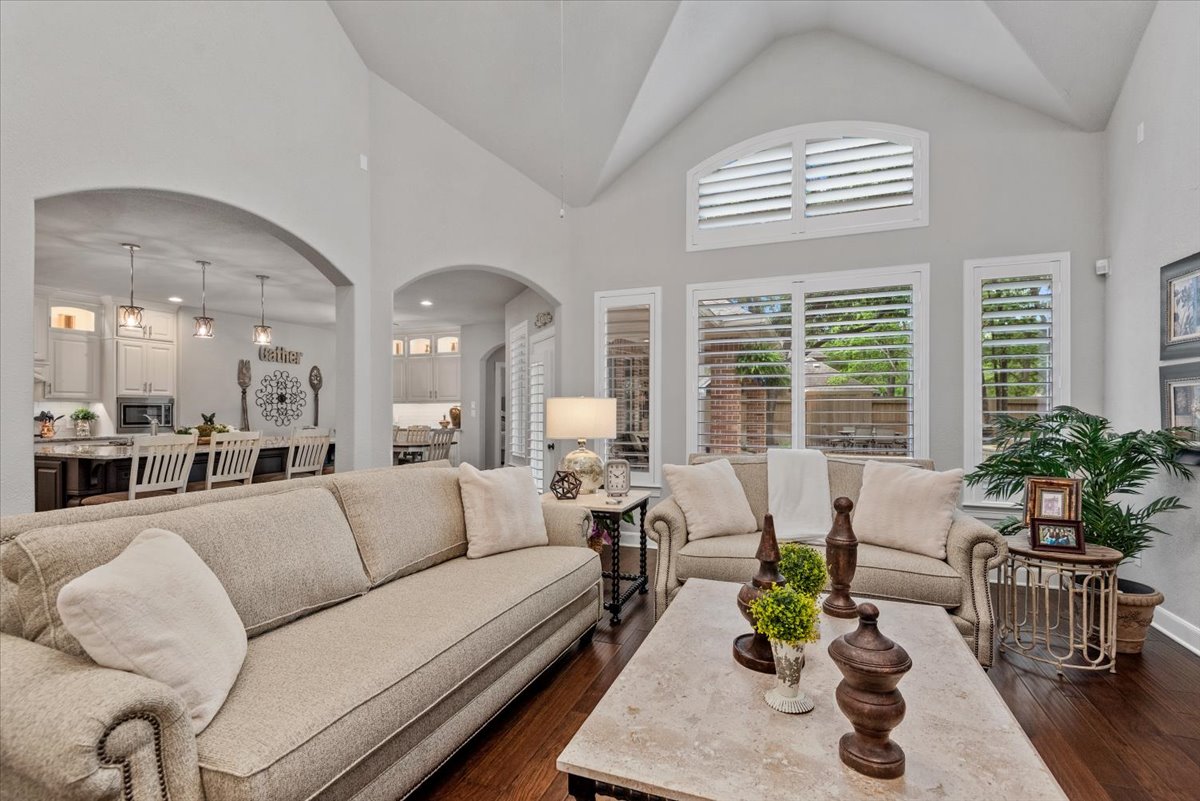 15519 Stallion Point Circle Cypress, TX 77429 - Photo 22 of 37 This inviting living space features high vaulted ceilings, large windows with plantation shutters, and dark hardwood flooring