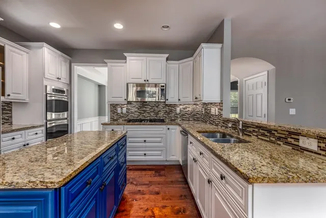 a kitchen with stainless steel appliances granite countertop a sink stove and cabinets