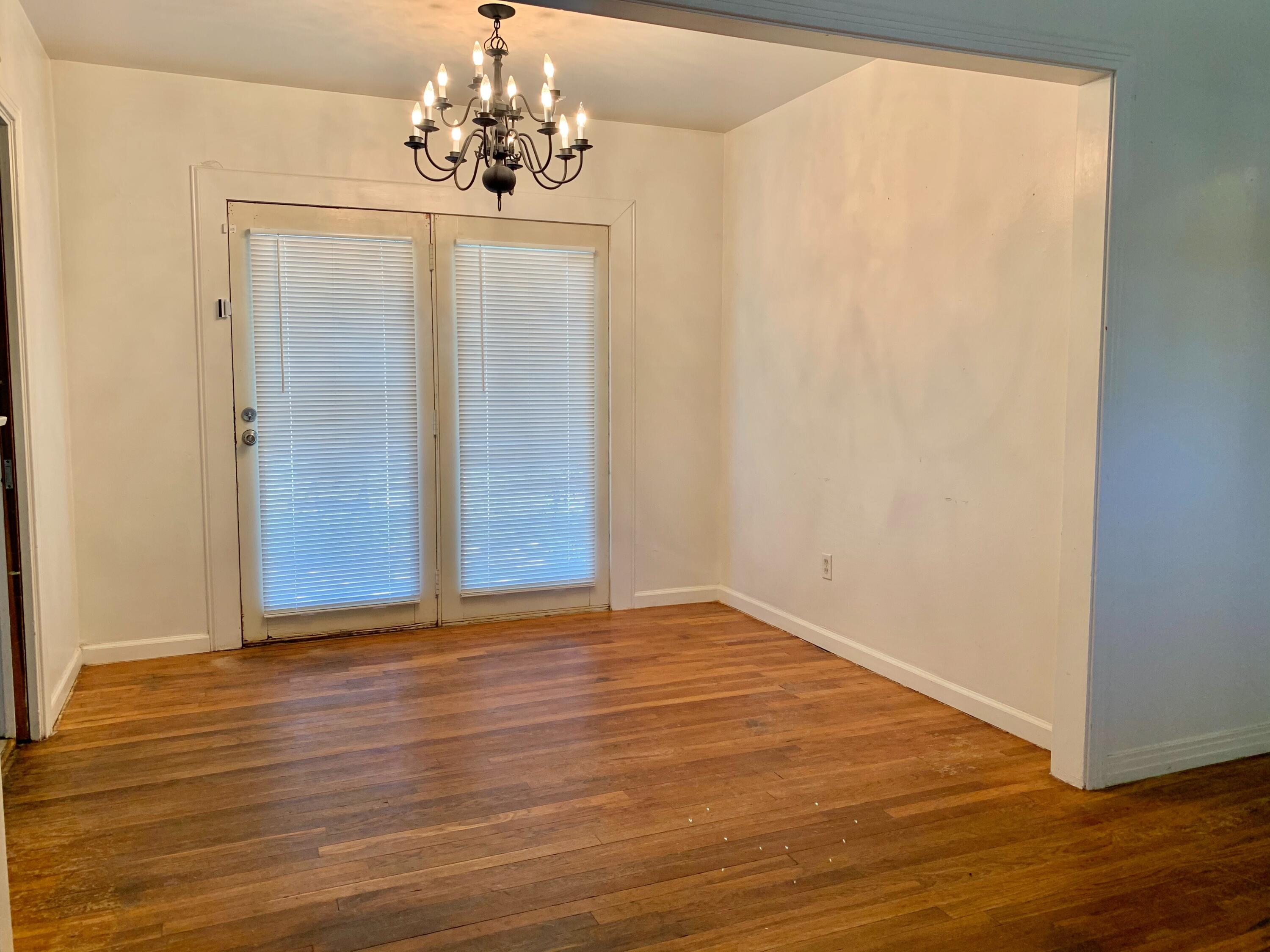 2510 39th Street Lubbock, TX 79413 - Photo 3 of 12 a view of a chandelier in an empty room with wooden floor