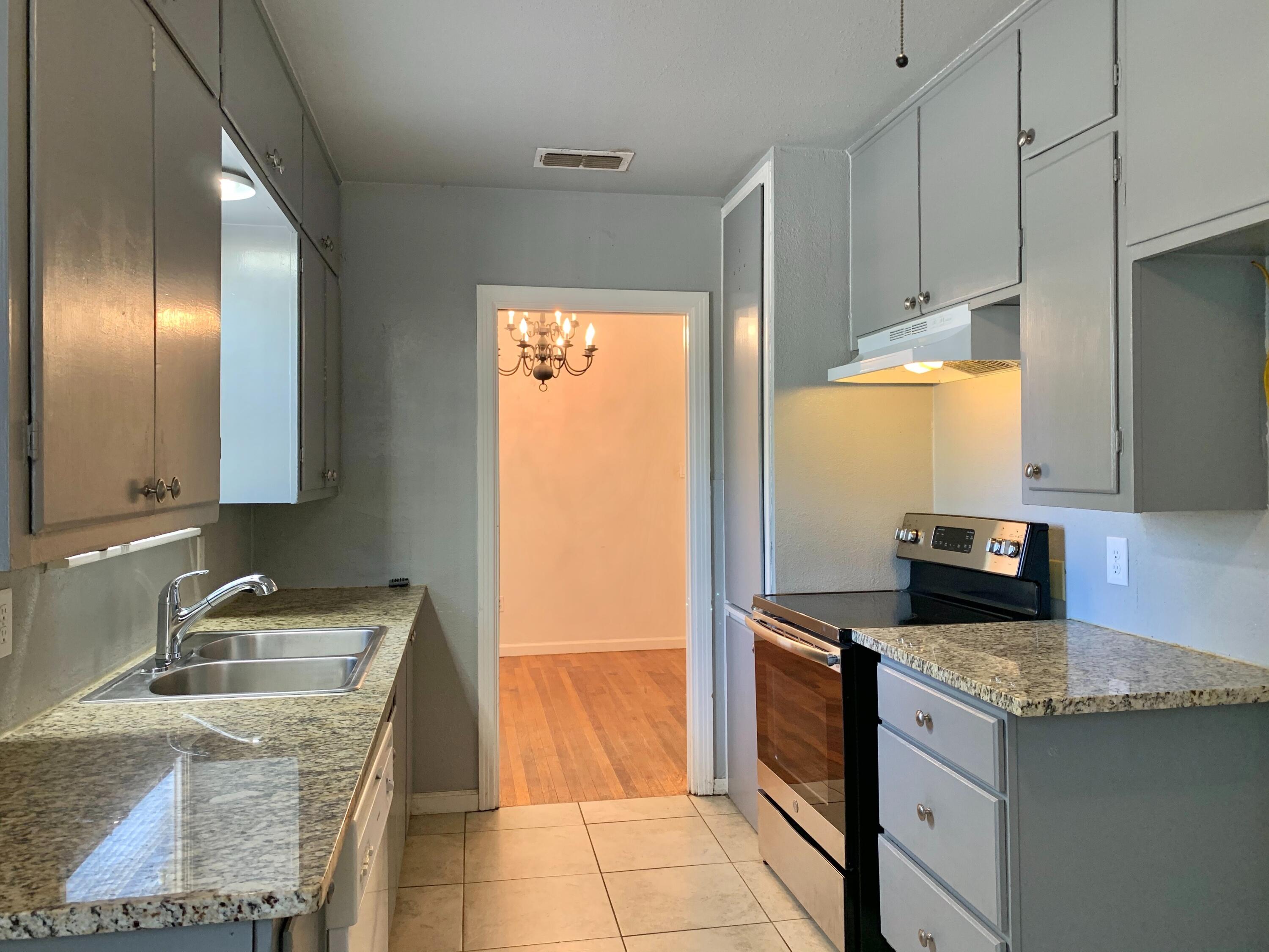 2510 39th Street Lubbock, TX 79413 - Photo 4 of 12 a kitchen with granite countertop stainless steel appliances a stove sink and cabinets