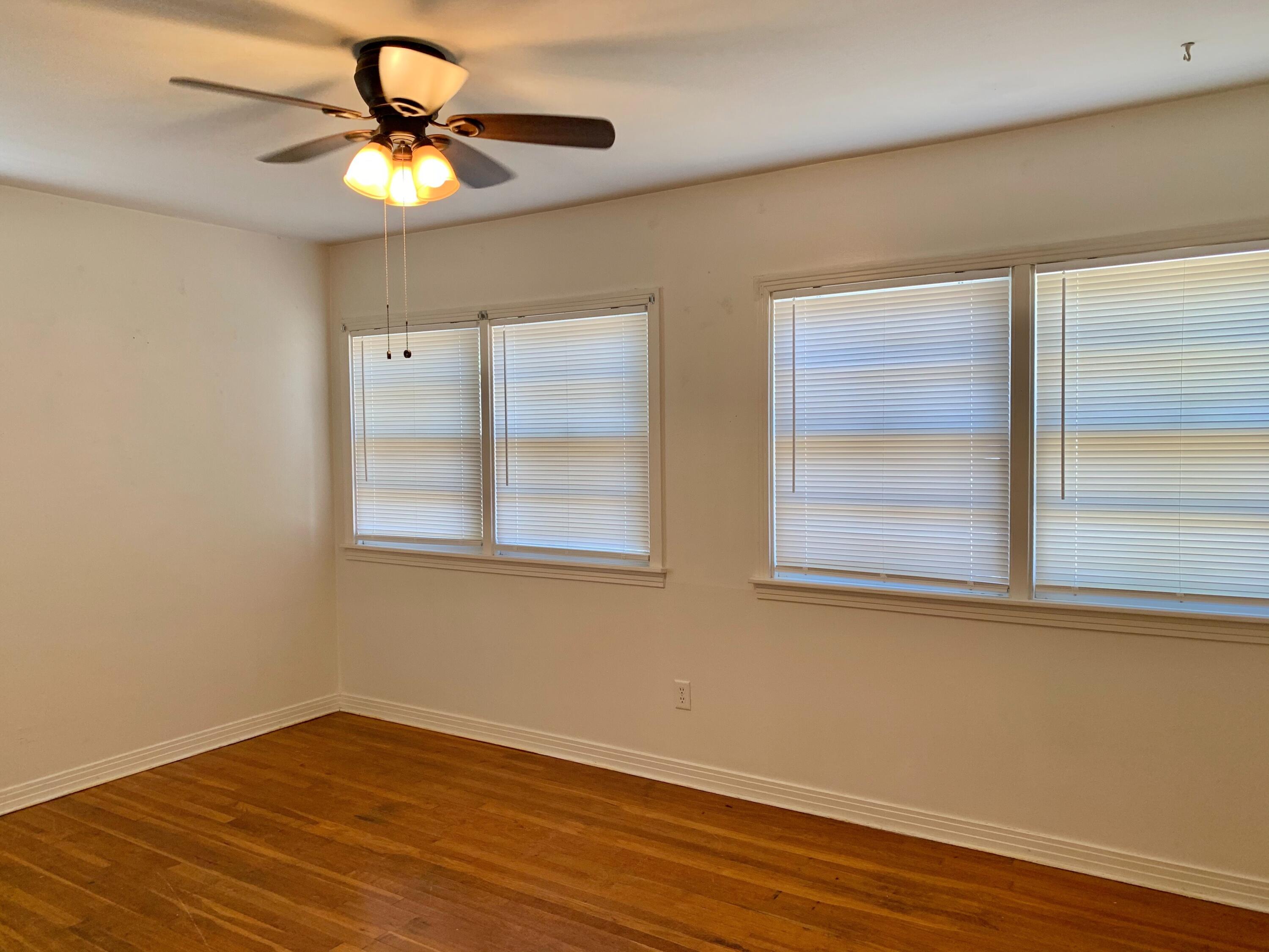 2510 39th Street Lubbock, TX 79413 - Photo 8 of 12 an empty room with wooden floor fan and windows