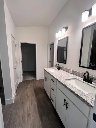 a bathroom with double vanity sink and a mirror
