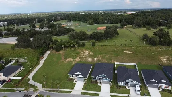 an aerial view of residential houses with outdoor space and lake view