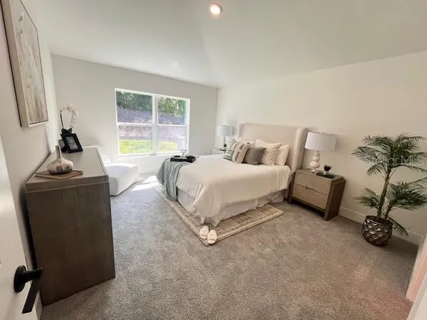 a bedroom with a bed a couch and a flat screen tv