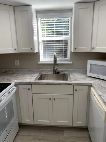 a kitchen with white cabinets and a sink