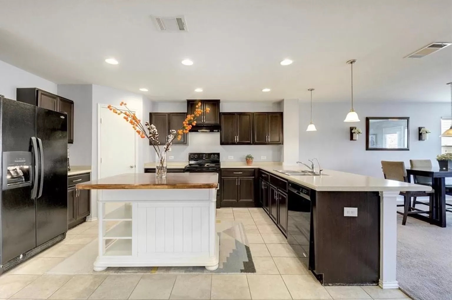 9016 Ridgewell Road Austin, TX 78747 - Photo 28 of 30 An inviting kitchen with a central island and dark wood cabinetry offers an open floorplan.