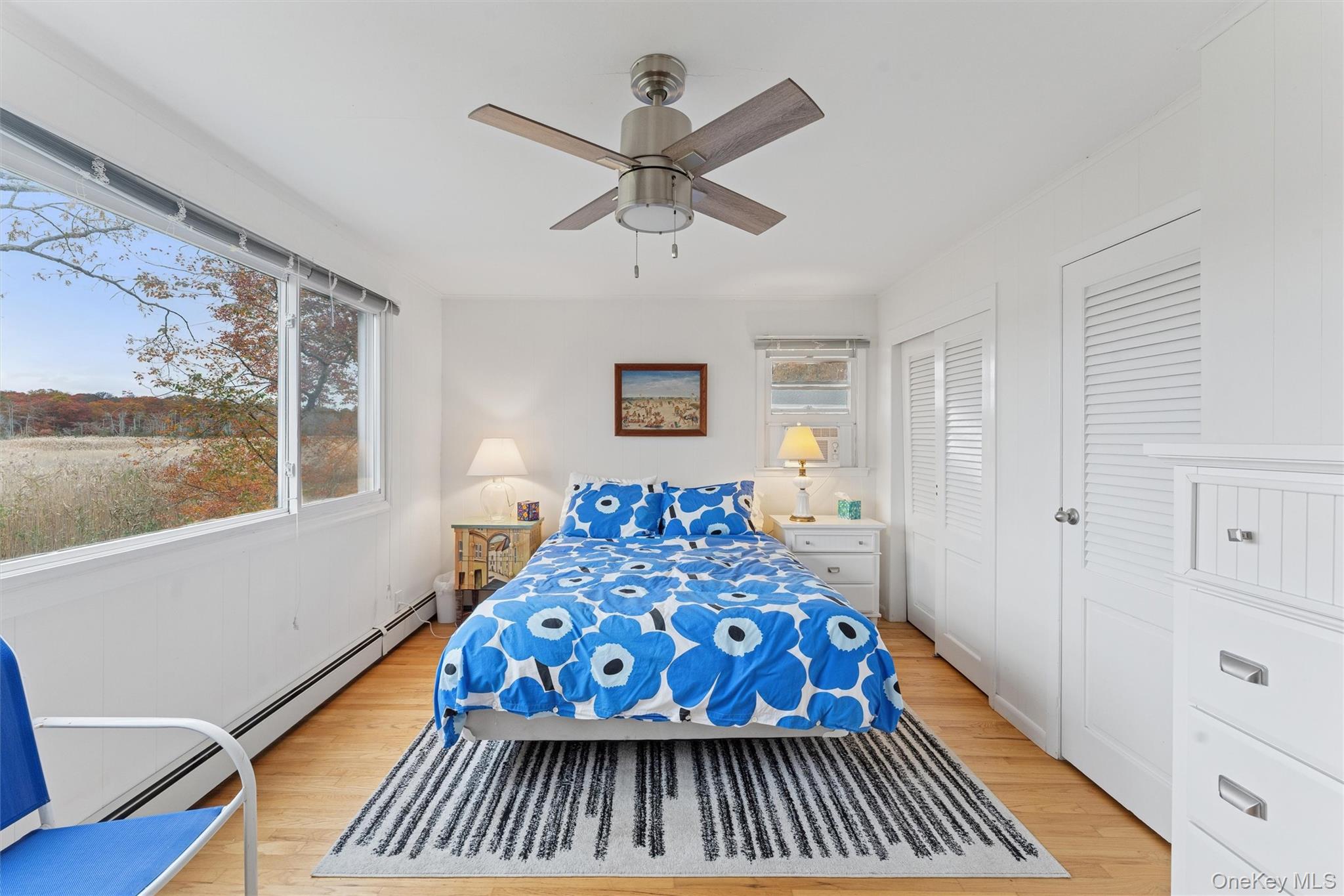 23 Old Main Road Quogue, NY 11959 - Photo 15 of 19 a bedroom with a bed and wooden floor