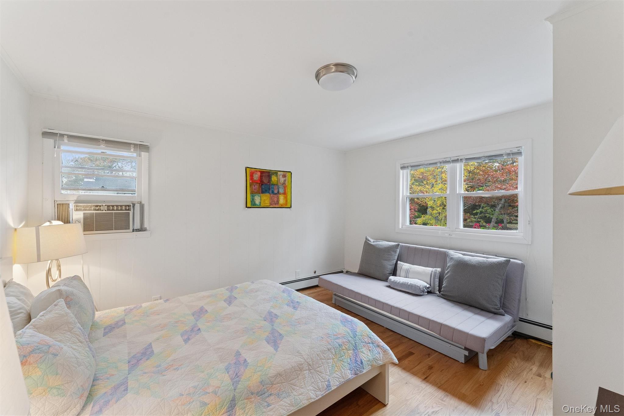 23 Old Main Road Quogue, NY 11959 - Photo 16 of 19 a bedroom with a bed and a couch