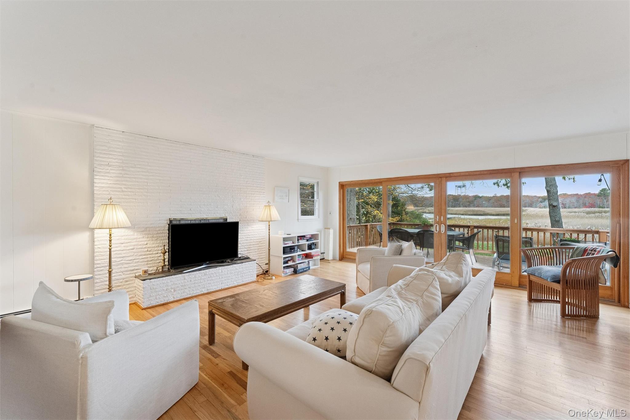 23 Old Main Road Quogue, NY 11959 - Photo 7 of 19 a living room with furniture and a flat screen tv