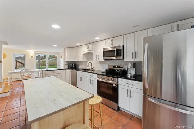 a kitchen with granite countertop a stove a sink dishwasher and a refrigerator