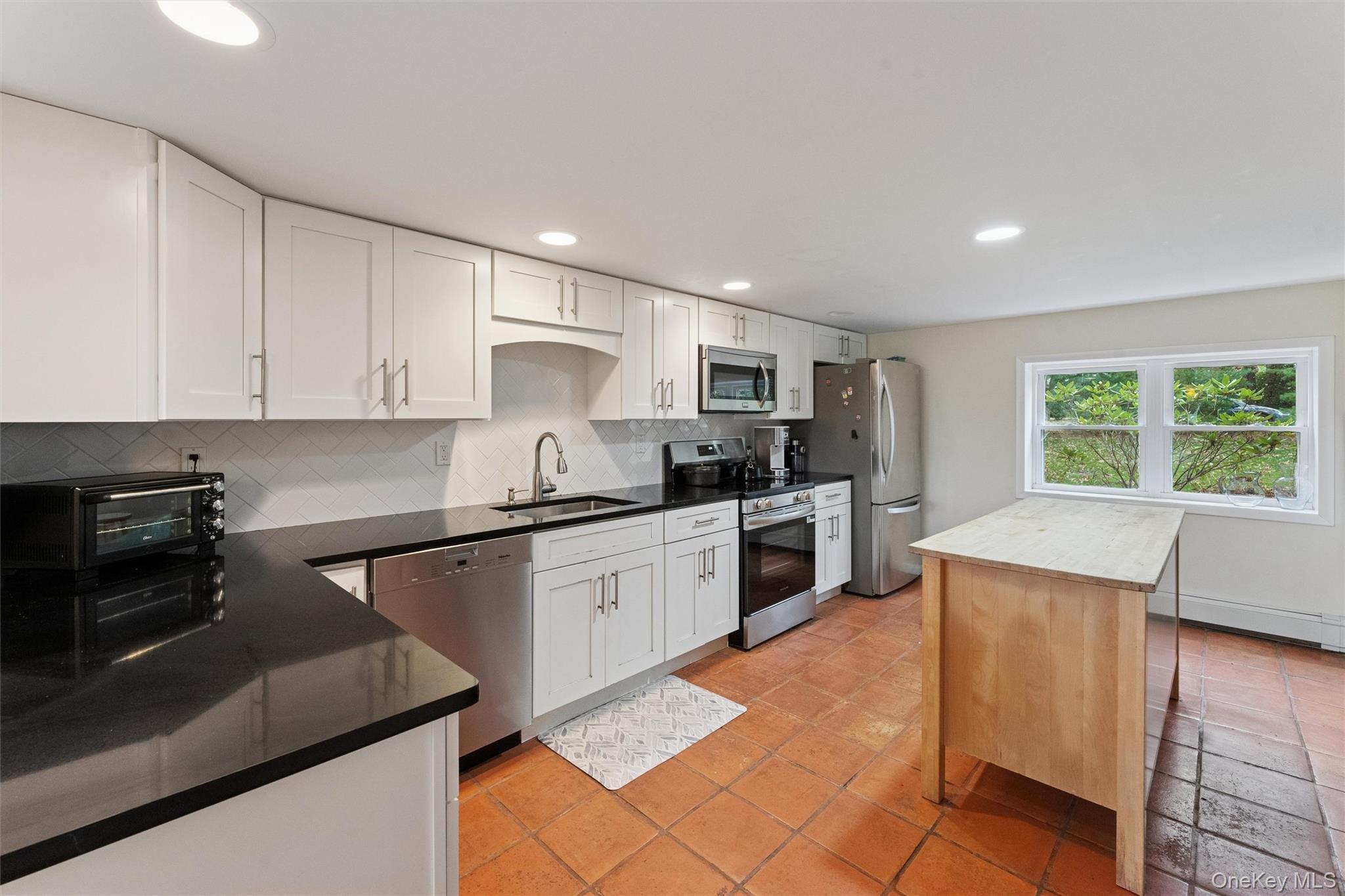 23 Old Main Road Quogue, NY 11959 - Photo 10 of 19 a kitchen with granite countertop a stove a sink dishwasher and a refrigerator