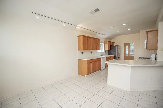 a large white kitchen with a sink a microwave and cabinets
