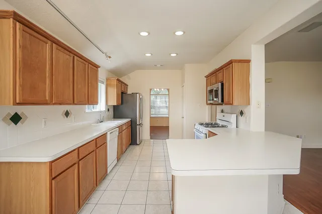 a large white kitchen with a sink and dishwasher