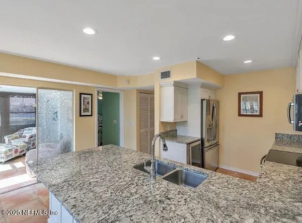 a kitchen with stainless steel appliances granite countertop a sink and center island