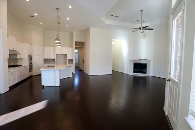a large white kitchen with lots of counter space and wooden floor