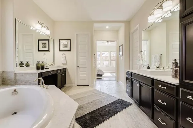 a en suite bathroom with a tub sink and mirror
