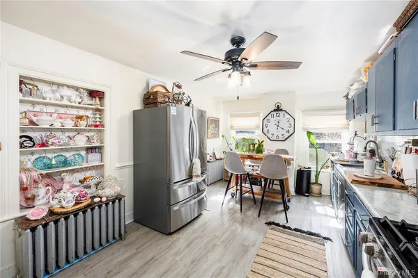 a view of a dining room and kitchen with furniture wooden floor and a clock