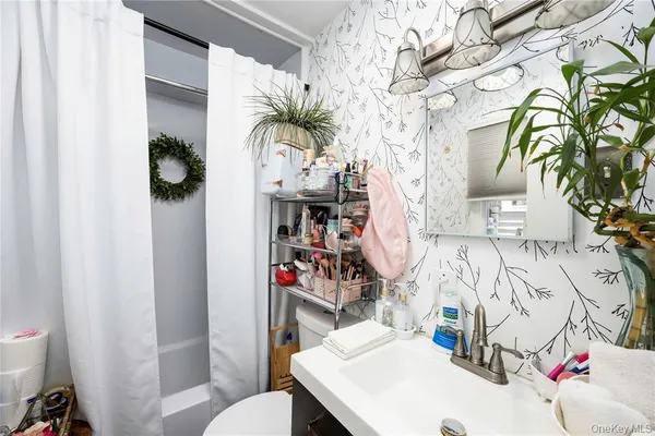 a bathroom with a sink a toilet and shower curtain