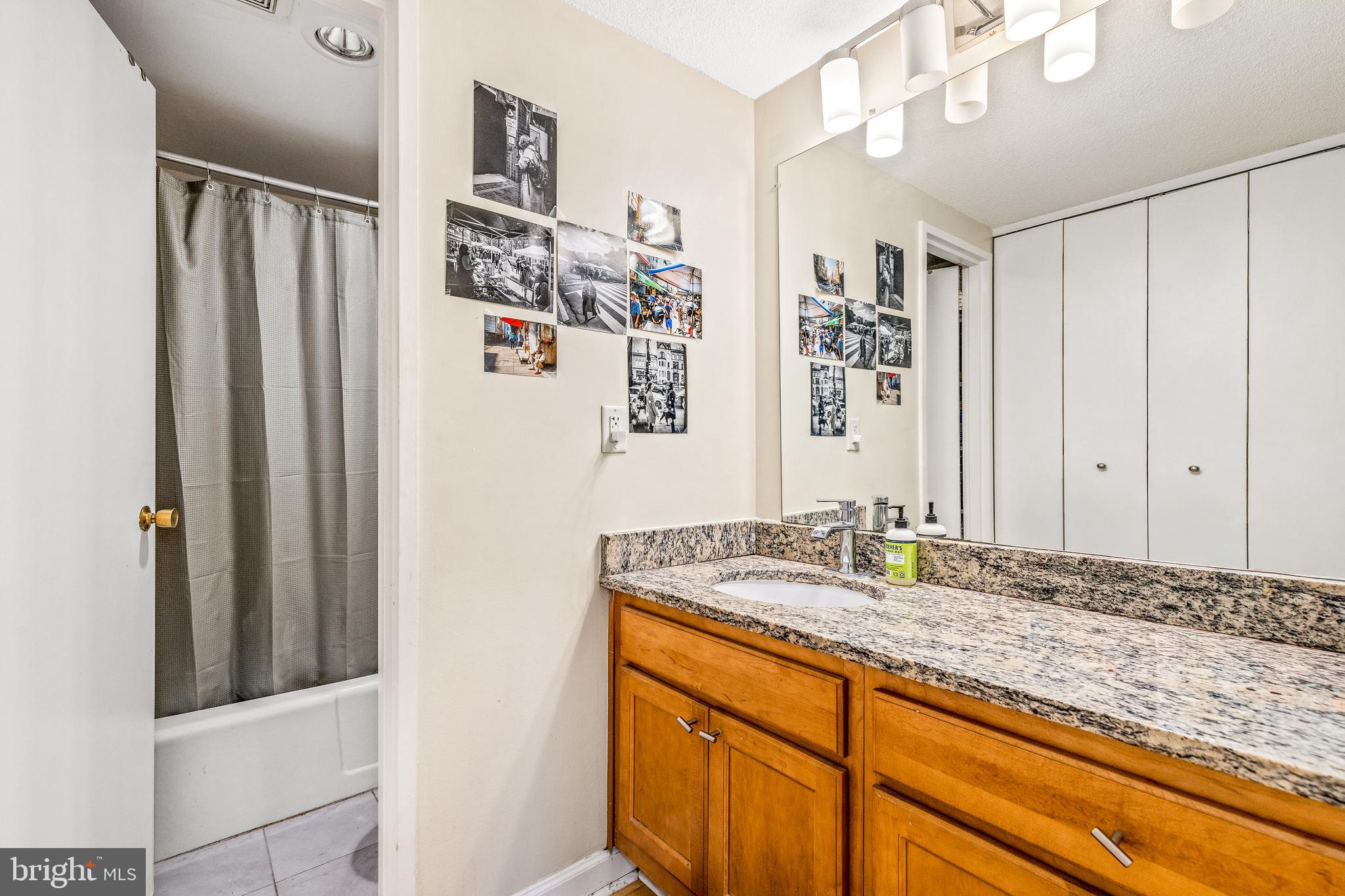 1718 P Street Northwest, Unit 509 Washington, DC 20036 - Photo 14 of 20 a bathroom with a granite countertop sink and a mirror