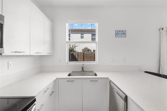 a kitchen with stainless steel appliances and white cabinets