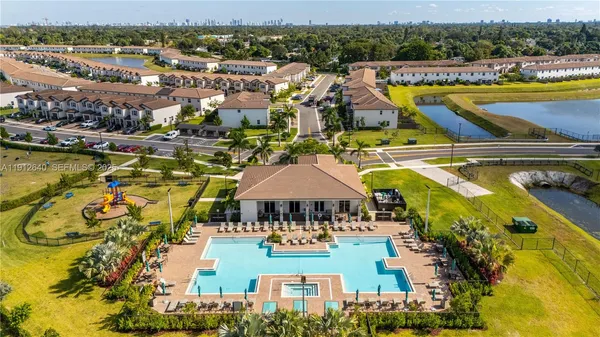 an aerial view of a swimming pool with outdoor seating and city view