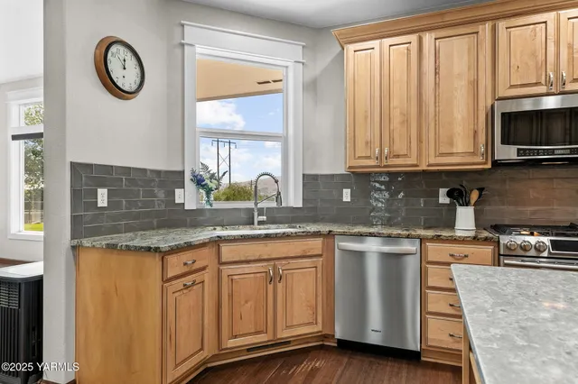 a kitchen with stainless steel appliances granite countertop a stove a sink and a microwave