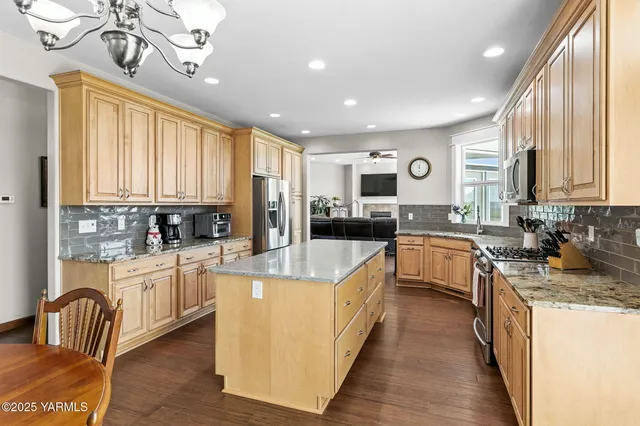 a large kitchen with stainless steel appliances granite countertop a sink and cabinets