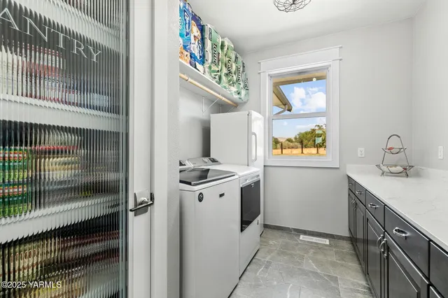 a utility room with cabinets washer and dryer