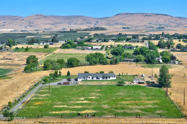 an aerial view of a houses with a yard and lake view