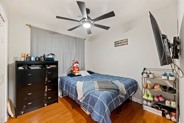 a bedroom with a bed and wooden floor