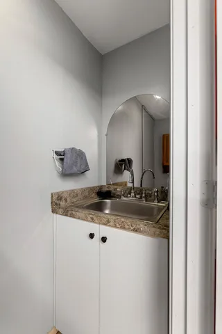 a bathroom with a granite countertop sink and a mirror
