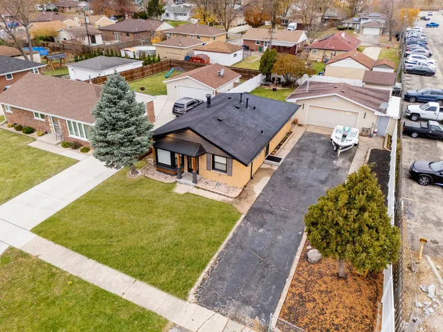 an aerial view of a house with garden space and a car park