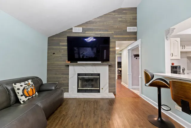 a living room with furniture a fireplace and a flat screen tv