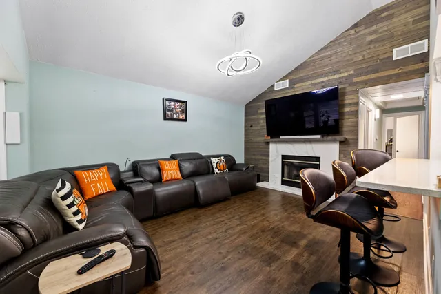 a living room with furniture a flat screen tv and a fireplace