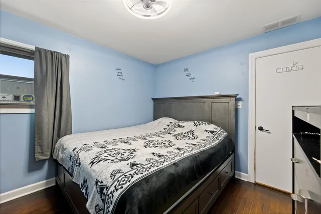 a bedroom with a bed and wooden floor