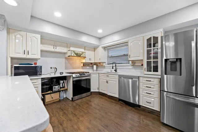 a kitchen with white cabinets and white appliances