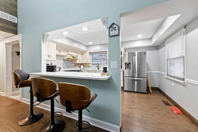 a kitchen with stainless steel appliances granite countertop a sink refrigerator and cabinets