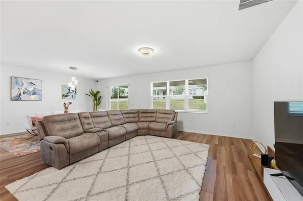 a kitchen with stainless steel appliances granite countertop a stove a sink a microwave a refrigerator and white cabinets