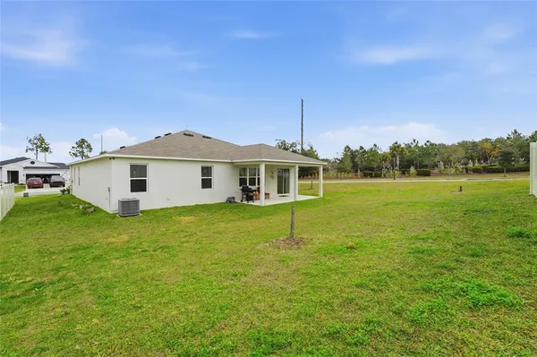 a front view of house with yard and ocean