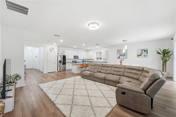 a living room with furniture white walls and potted plants