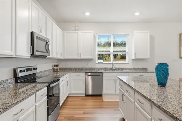 a kitchen with stainless steel appliances granite countertop a sink stove and cabinets