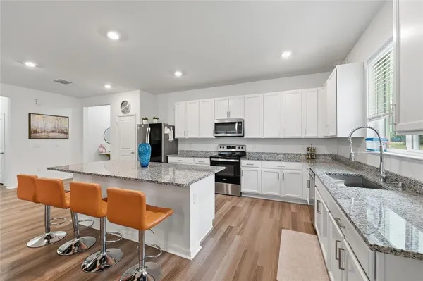 a large kitchen with stainless steel appliances granite countertop a lot of counter space