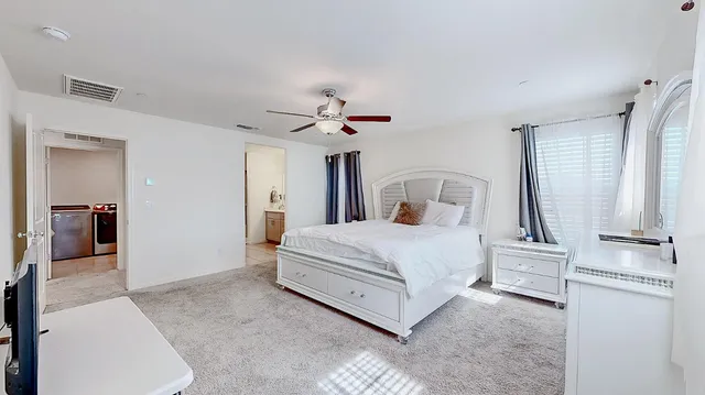 a bedroom with a large bed and a chandelier