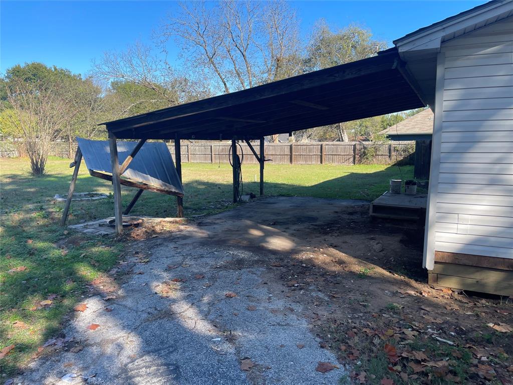 301 Walnut Street Chandler, TX 75758 - Photo 11 of 13 a view of a backyard with a wooden fence