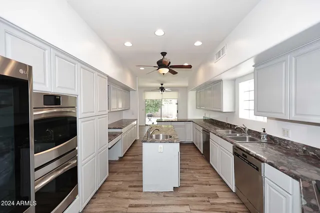a large kitchen with stainless steel appliances granite countertop a stove and a sink