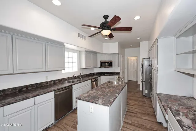 a kitchen with stainless steel appliances granite countertop a sink stove and refrigerator