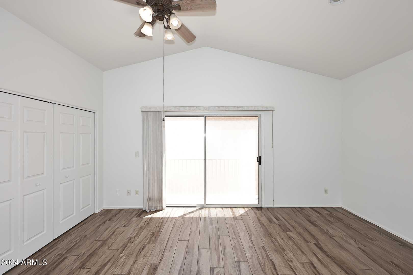 6006 North 5th Place Phoenix, AZ 85014 - Photo 21 of 34 an empty room with wooden floor chandelier fan and windows