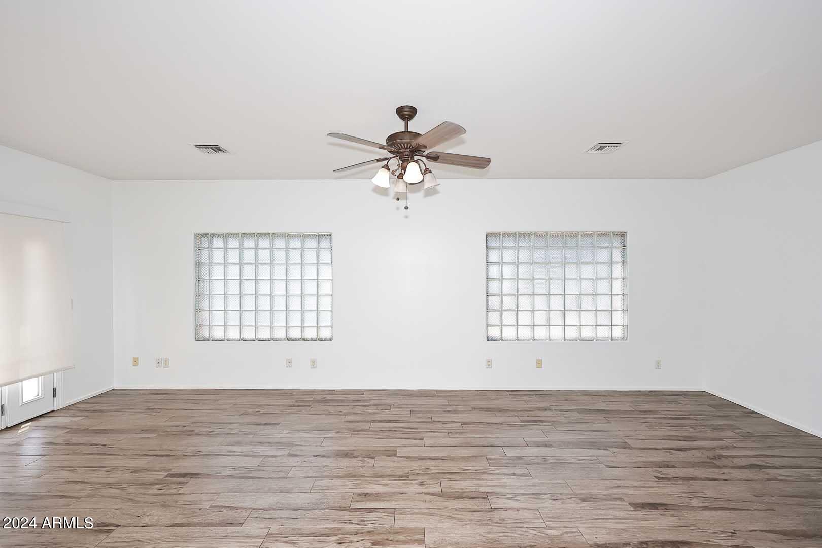 6006 North 5th Place Phoenix, AZ 85014 - Photo 23 of 34 a view of an empty room with wooden floor and a ceiling fan