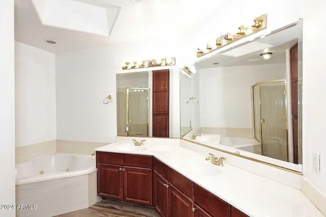 a bathroom with a tub sink and mirror
