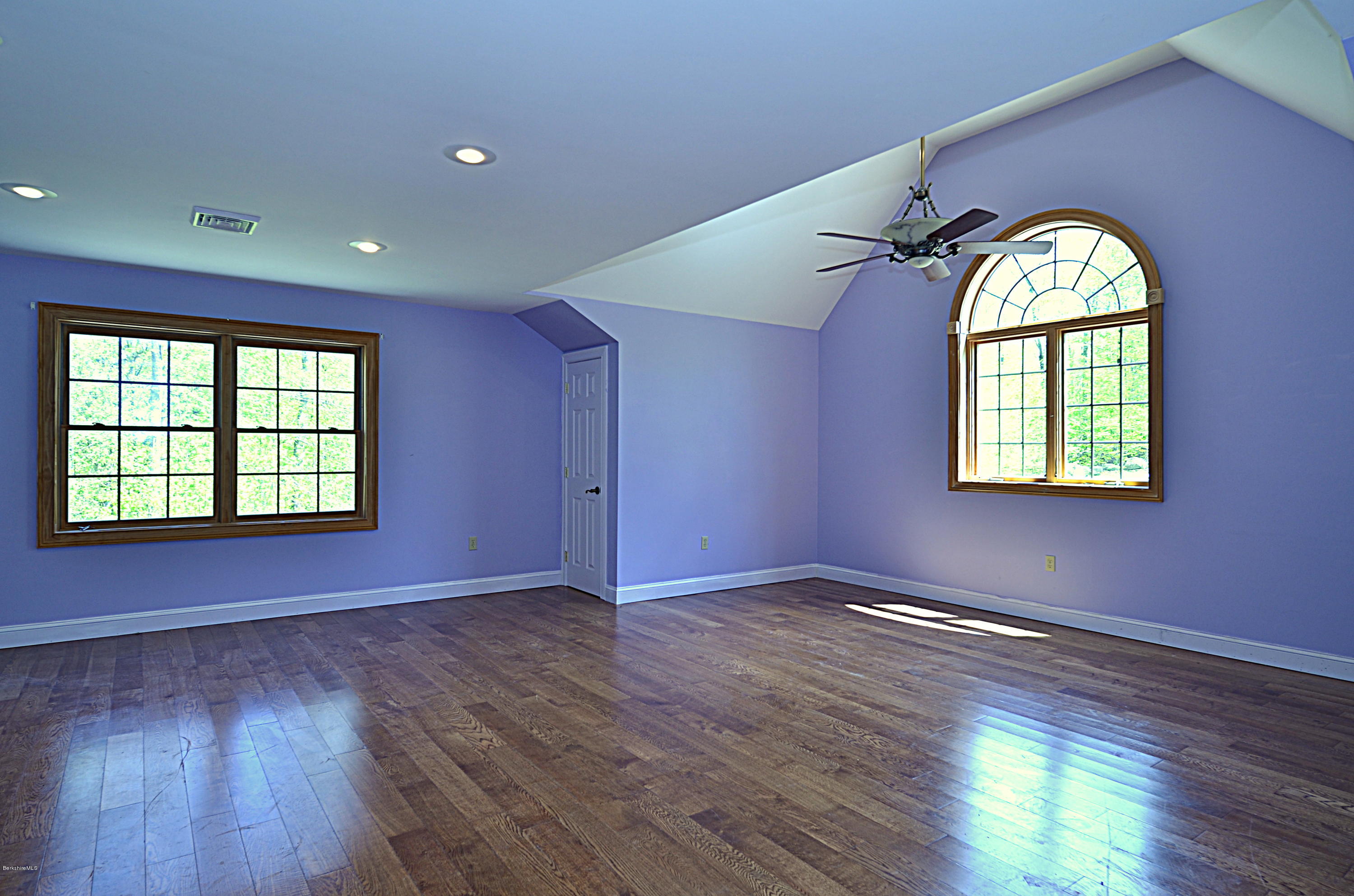 317 Skyline Ridge Road Becket, MA 01223 - Photo 19 of 29 an empty room with wooden floor windows and glass door